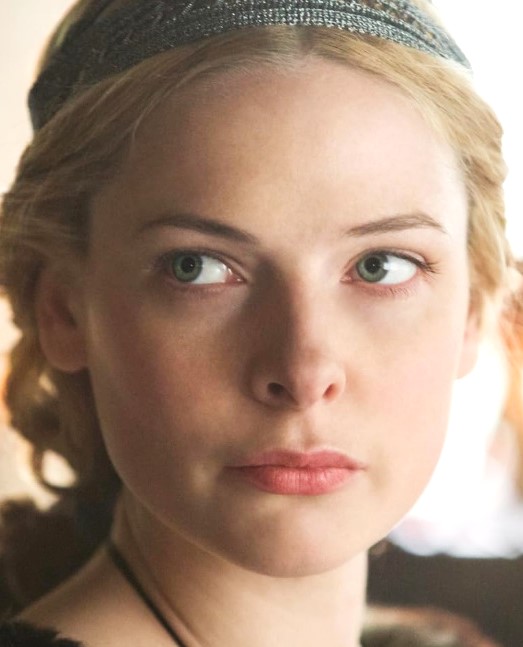 Close-up of a young woman with blonde hair and a sparkly headband, looking to the side with a thoughtful expression.